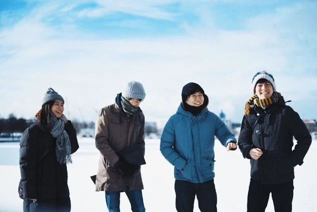 雪原で笑顔を見せる4人組。リゾートバイトは、同じ趣味を持つ仲間と出会う最高の場所です。