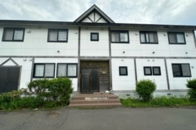 リゾートバイトの社員寮のイメージ画像。白を基調とした、2階建てのシンプルな建物の外観。