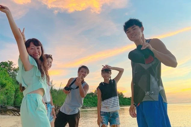 夕暮れのビーチで楽しむリゾートバイトの仲間たち。沖縄や離島での生活は、オフの時間も最高の思い出になります。