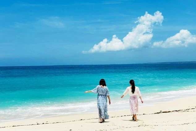 青い空とエメラルドグリーンの海を歩く女性たち。憧れのビーチリゾートで働きながら、南国ライフを満喫できます。