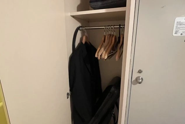 リゾートバイトの寮に備え付けられたクローゼット。洋服をかけるハンガーラックがあり、収納スペースが確保された寮の設備の画像。