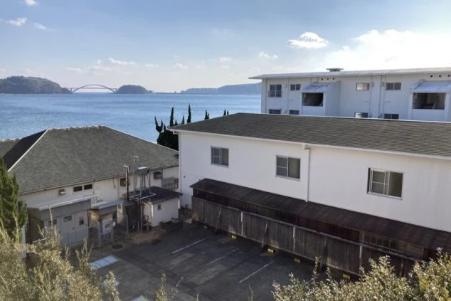 リゾートバイト寮の外観。海の近くに位置し、遠くには橋が見える、ロケーションの良い住み込み寮の画像。