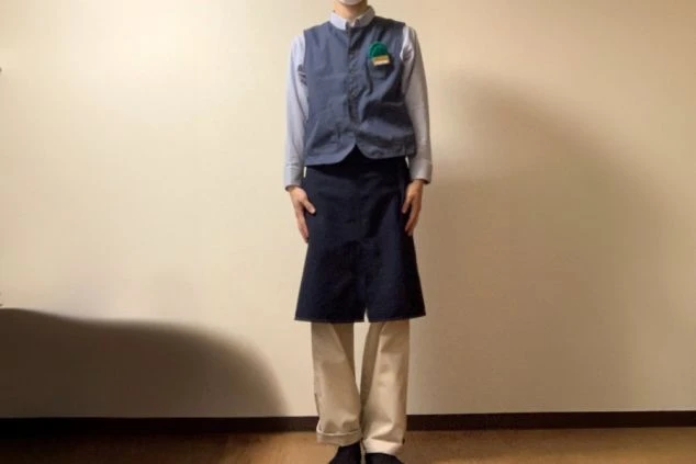 レストランの制服画像。さわやかな青いシャツにサロンを巻いている。
