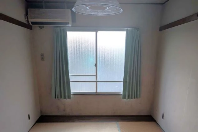 エアコンと照明が完備された、シンプルで清潔感のある和室タイプの寮個室の画像。