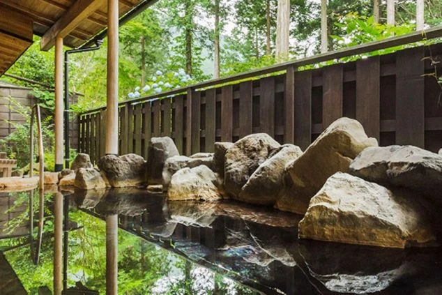 リゾートバイトの求人がある旅館の露天風呂。自然に囲まれた岩風呂で、仕事終わりに温泉を楽しめる。