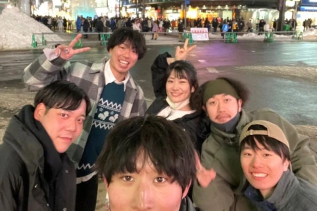 函館山からの夜景を背景に、函館山ロープウェイの乗車券を持つ2人の手元が写っている。リゾートバイトの休日に、日本三大夜景を楽しめることをアピール。