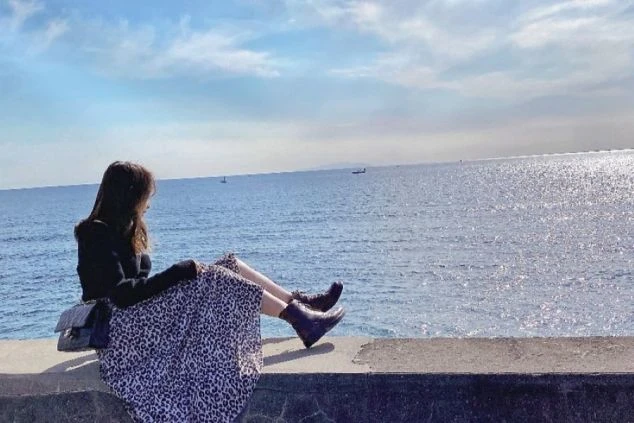 江の島の海を眺める女性の横顔。ヒョウ柄のロングスカートとブーツ姿で、海辺でくつろぐ様子から、リゾートバイトの休日を満喫できることを示すワクトリオリジナル画像。