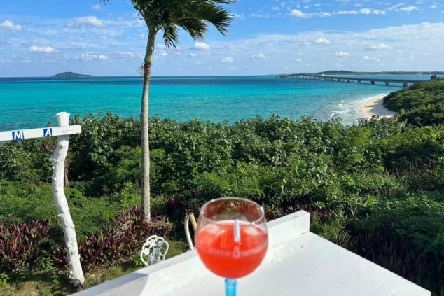 沖縄の美しい海を望む絶景とカクテル。リゾートバイトで仕事の後にリラックス。沖縄の離島やビーチリゾートでの求人を探している方におすすめ。