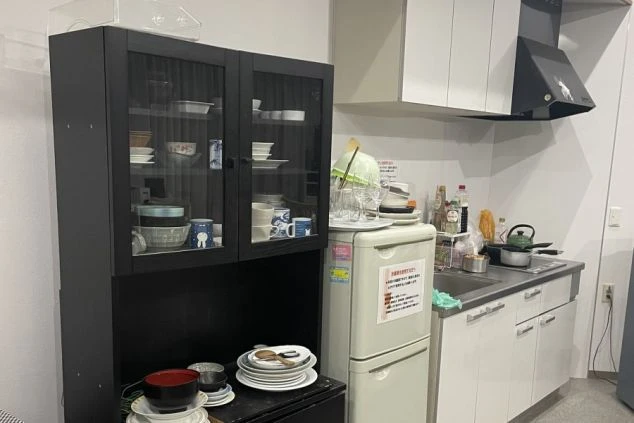食器棚と冷蔵庫、調理スペースがある共同キッチン。