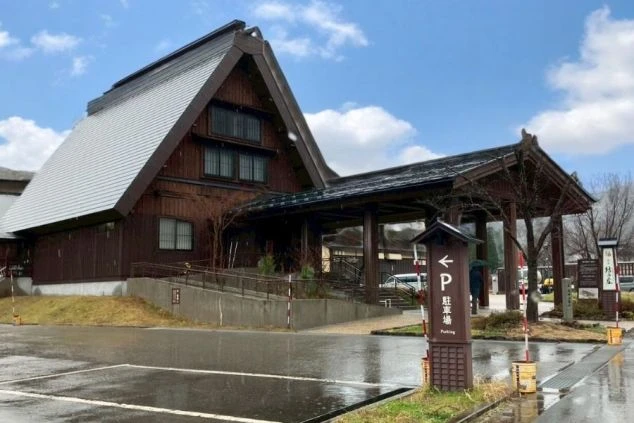 合掌造り風の屋根が特徴的な、風情ある岐阜県白川郷エリアの温泉旅館の玄関アプローチの画像。