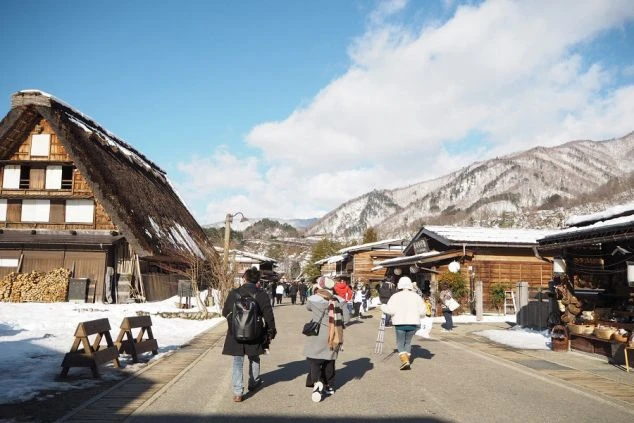 合掌造り風の屋根が特徴的な、風情ある岐阜県白川郷エリアの温泉旅館の玄関アプローチの画像。
