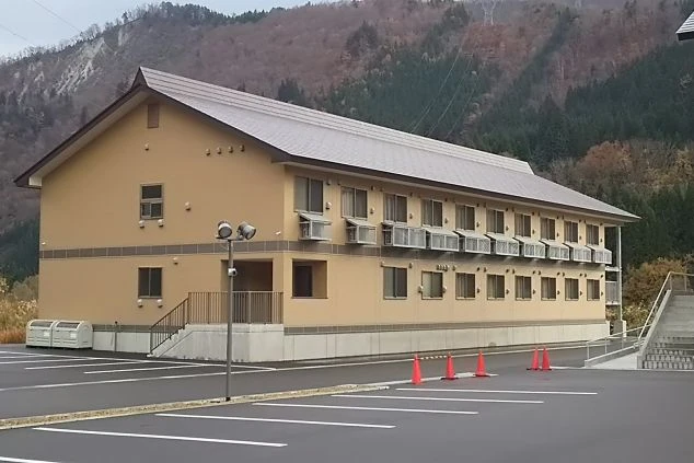 リゾートバイトの女性寮の外観。山を背景にした、静かな環境にあるアパートタイプの建物です。