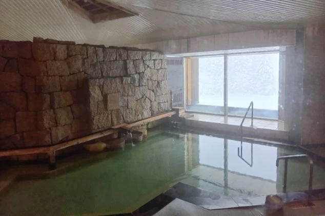 スタッフも利用可能な温泉大浴場の画像。雪景色を眺めながら入れる贅沢な源泉かけ流しの湯。