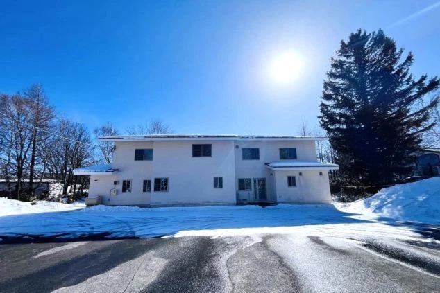 冬のリゾートバイト住み込み寮。青空に映える綺麗な外観で、白銀の世界に囲まれた静かな生活環境。