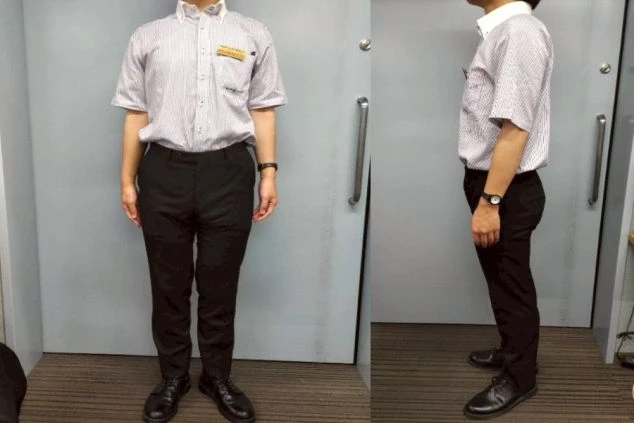 フロントで働く男性スタッフの制服。ストライプのシャツに黒いパンツを合わせた、爽やかで動きやすい夏のスタイル。