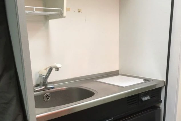 リゾートバイトの寮に完備されたミニキッチン。IHクッキングヒーターとシンクがあり、自炊で食費を節約できる。
