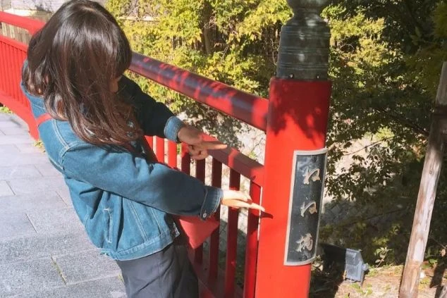 有馬温泉のねね橋で、観光を楽しむリゾートバイト中の女性。仕事の合間や休日に、歴史ある温泉街を散策。