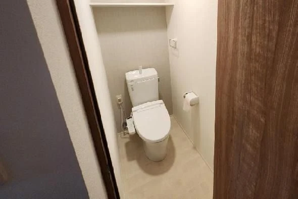 白い浴槽とシャワー、紺色の壁が特徴のシンプル浴室。