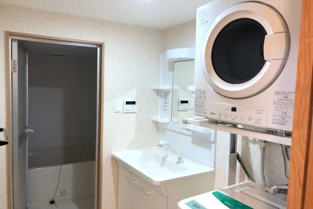 洗濯機と独立洗面台のある洗面所の画像。