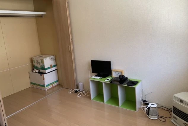 リゾートバイトの寮施設の部屋の写真。白い壁に木目調のフローリング。収納のできるクローゼットが写されている。