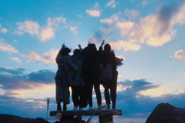 夕焼けの空を背景に肩を組み合う若者たちのシルエットの画像。リゾートバイトで出会う仲間との絆や思い出を象徴。