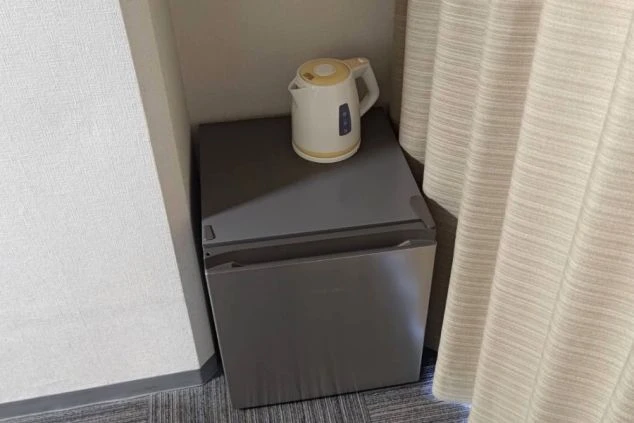 リゾートバイトの寮の部屋に備え付けられた冷蔵庫と電気ケトルの画像。リゾートバイト中の生活に役立つ家電が揃っている。リゾートバイトの寮の部屋の画像。
