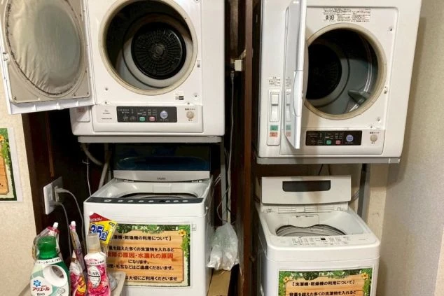 リゾートバイトの寮にある共用のランドリー。洗濯機と乾燥機が上下に設置されており、生活に便利な設備が整っている。