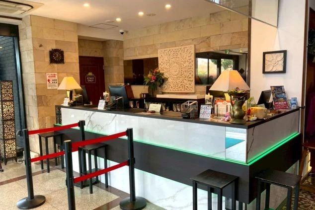 ホテルのロビーにある豪華な階段の画像。柄物の絨毯が敷かれ、上階へと続く手すりが特徴的。リゾートバイトの職場となる施設の雰囲気。