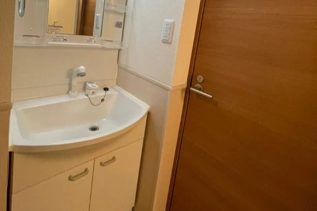 ワクトリの社員が出張で撮影した、洗面台の画像。大きな鏡と収納付きの洗面台が設置されており、シンプルなデザインで清潔感がある。リゾートバイト中の身だしなみに便利な設備。