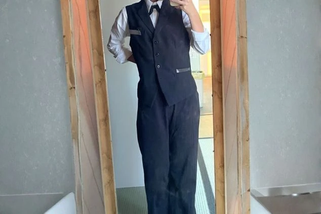 レストランスタッフの制服画像。白シャツに黒のベストとネクタイを合わせた、清潔感のあるフォーマルな装い。