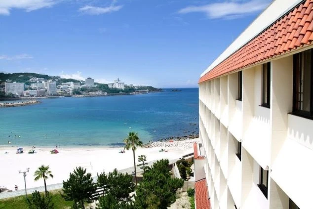 南紀白浜の美しいビーチに映える白いホテルの外観写真。