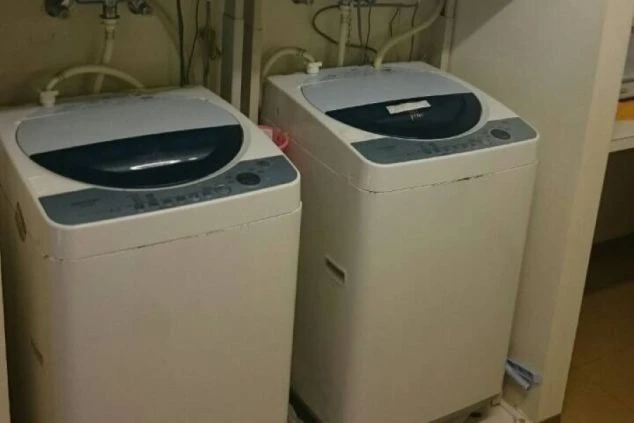 箱根の旅館でリゾートバイトするスタッフが住む寮の洗濯機の画像。