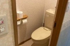 リゾートバイトの寮(従業員宿舎)にある、清掃が行き届いたトイレ。トイレットペーパーホルダーと棚付き。