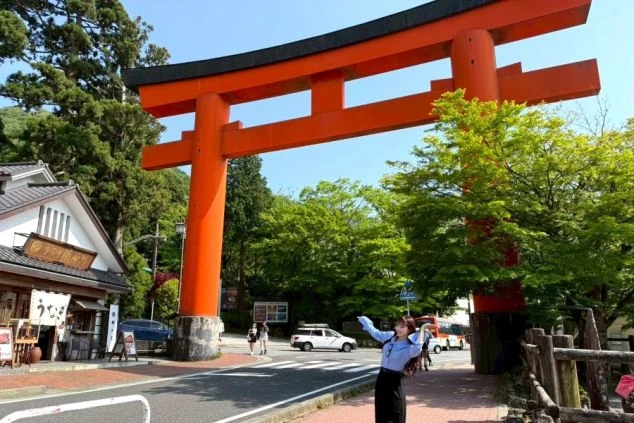 箱根芦ノ湖のほとりに立つ巨大な赤い鳥居の前で、ポーズをとって記念撮影をするワクトリスタッフの画像。