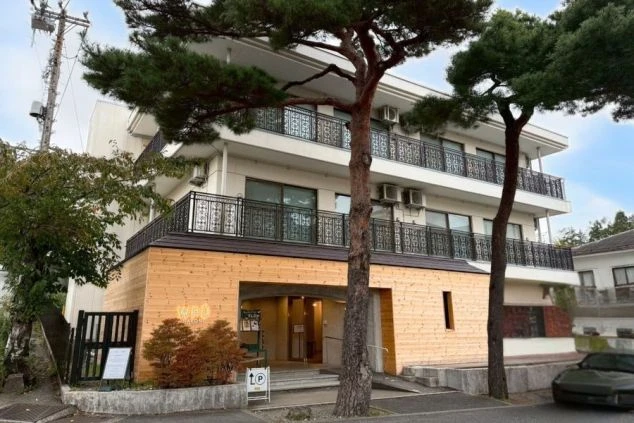 木目調の壁に大きなアーチ状の入口がある建物。箱根の強羅駅付近にあるホテルの外観画像。