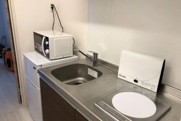 リゾートバイトの寮に完備されたキッチンの画像。電子レンジやIHコンロ付きで自炊可能。