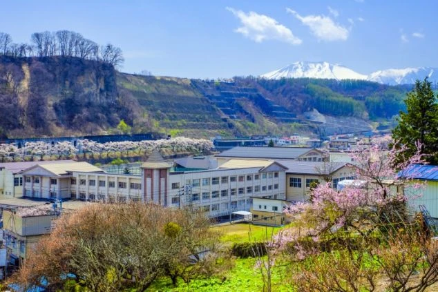 リゾートバイトの休日に観光するイメージ画像。群馬県万座温泉にある、ゴツゴツとした岩肌と白く濁った川が流れる「万座空吹」の風景。
