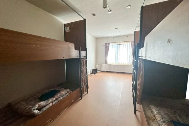 二段ベッドが向かい合って並ぶリゾートバイトの寮の部屋の画像。