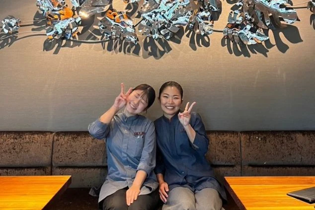 夕暮れの美しい空を背景に一人の人物のシルエットが写っています。空はオレンジ、ピンク、紫の色が混じり合い、ドラマチックなグラデーションを見せ、人物は顔がはっきりと見えず神秘的な雰囲気を醸し出しています。