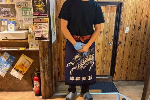 麒麟麦酒のロゴ入り前掛けを着用した飲食店のホールスタッフ