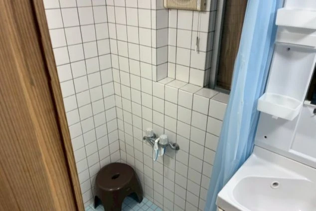 タイル貼りのシャワールームと洗面台