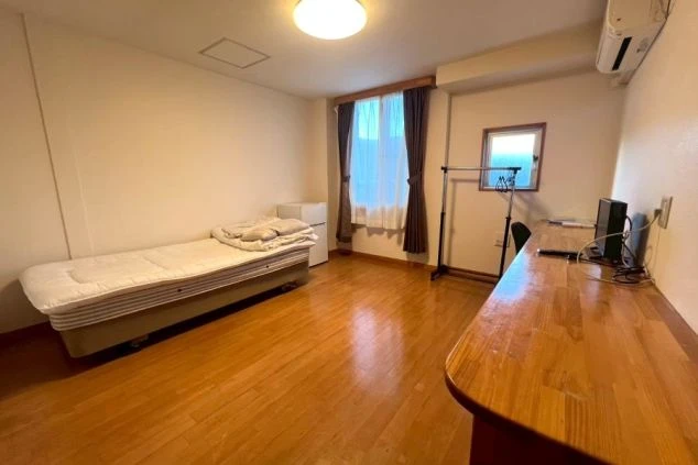 リゾートバイトの完全個室寮。ベッド、テレビ、冷蔵庫、広いデスクが完備された、すぐに暮らせる快適な洋室。