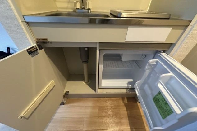 シンク下の収納スペースと、その中にあるミニ冷蔵庫。