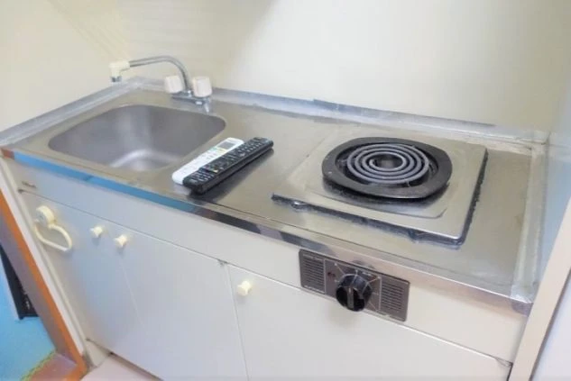 寮の個室内にあるミニキッチン。小さなシンクと電気一口コンロが備わっています。
