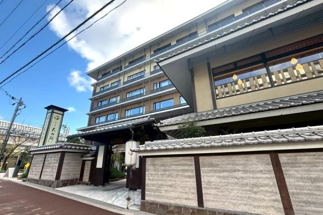 ライトアップされたモダンで美しい旅館の外観。日本の古都、京都で働きながら、伝統文化に触れる貴重な経験ができます。