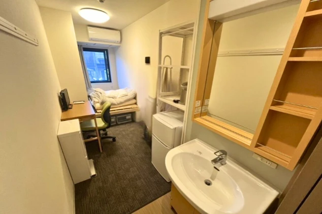 ワクトリの社員が出張で撮影した、寮の部屋の画像。和室にベッドが置かれたシンプルな空間で、エアコン、小型冷蔵庫、テレビが完備されている。リゾートバイト中の生活基盤となる部屋の様子。