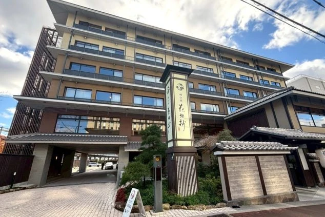 京都嵐山の渡月橋と桂川の風景。紅葉に色づく山々を背景に、美しい橋と清流が広がる。日本の風情を感じられるこの場所は、リゾートバイトで訪れることのできる魅力的な観光地。