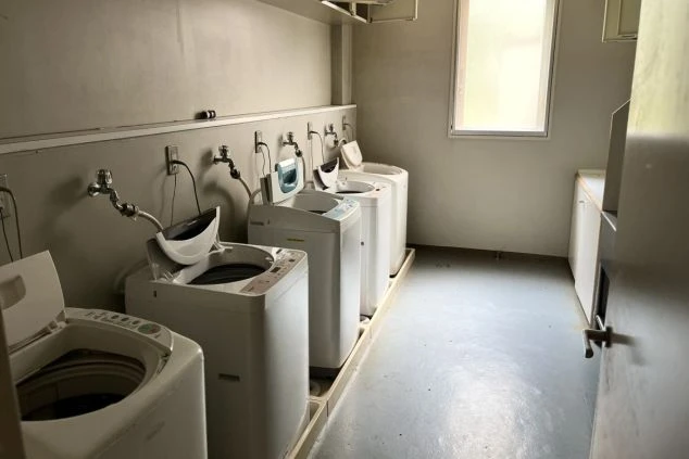 窓があり明るい、リゾートバイト寮の共同ランドリー。複数の洗濯機を完備。