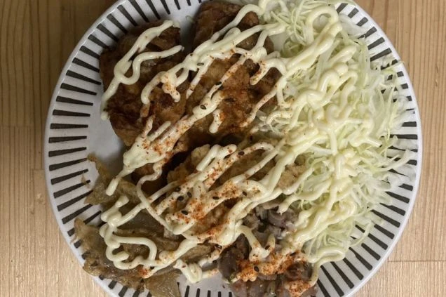 リゾートバイトのまかない(食事)例。揚げ物とキャベツが盛られた一皿。