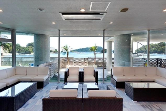 鳥羽にあるホテルのロビーの画像。開放的な空間に白いソファが並び、大きな窓からは鳥羽の海と島々が見渡せる。リゾートバイトの職場となる、景色が素晴らしいホテルロビー。